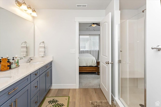 1088 N Freeman Dr, Saratoga Springs, UT 84045 - bathroom featuring a sink, double vanity, visible vents, wood finished floors, and a shower stall