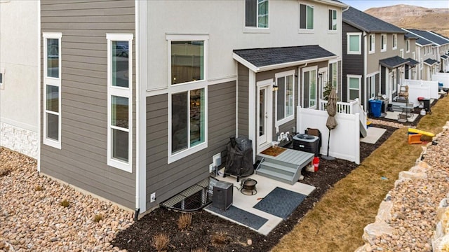 1088 N Freeman Dr, Saratoga Springs, UT 84045 - back of house featuring a patio area, a shingled roof, and a mountain view