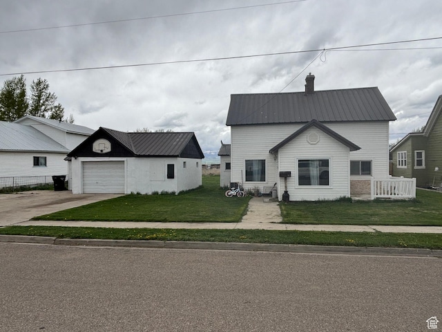 353 S 9th St, Montpelier, ID 83254 - view of front facade with a front lawn, concrete driveway, metal roof, and a garage