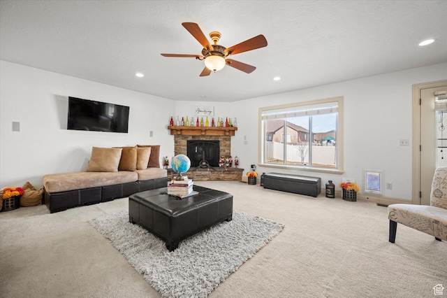 carpeted living room featuring ceiling fan and a fireplace