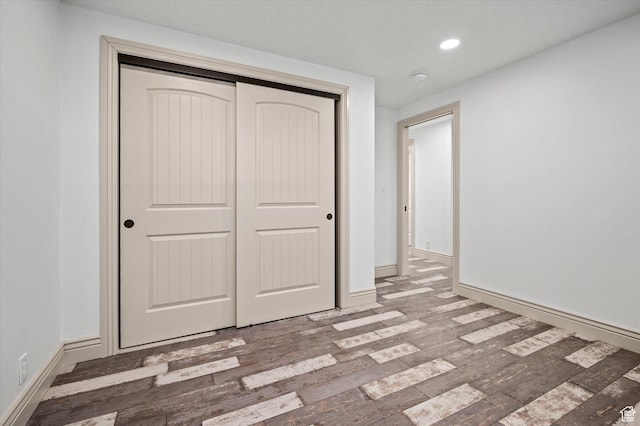 unfurnished bedroom with hardwood / wood-style floors and a closet