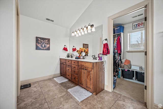 bathroom with vanity, tile patterned floors, and lofted ceiling