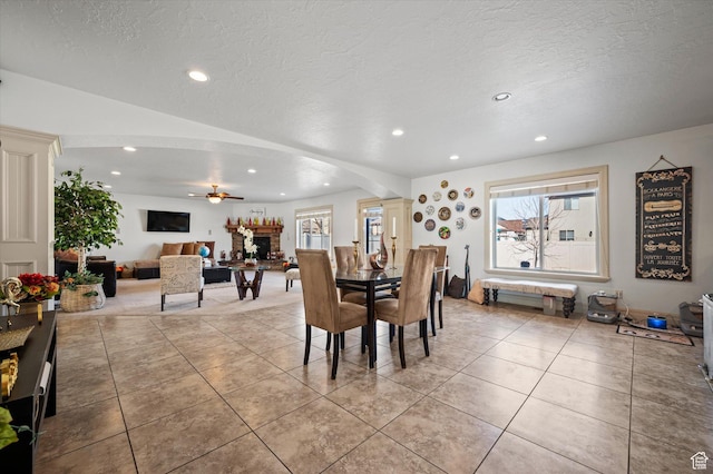 dining space featuring light tile patterned flooring, ceiling fan, and a textured ceiling