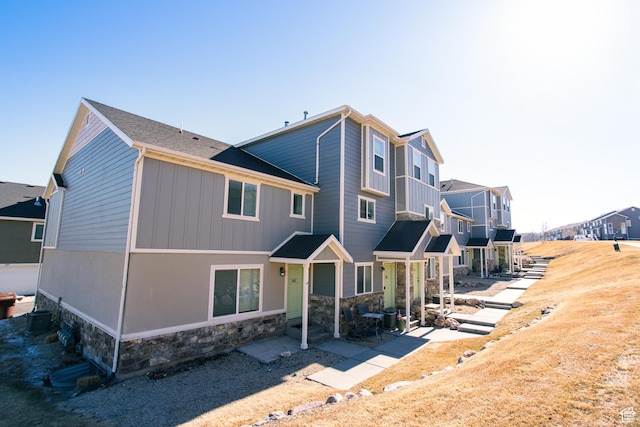 14368 S Penrhy Ct, Herriman, UT 84096 - rear view of property featuring stone siding, a residential view, and central AC unit