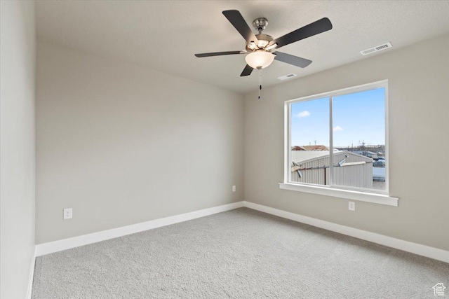 empty room featuring carpet flooring, baseboards, and visible vents