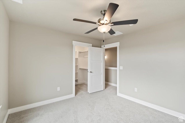 unfurnished bedroom featuring a closet, baseboards, carpet floors, and a spacious closet