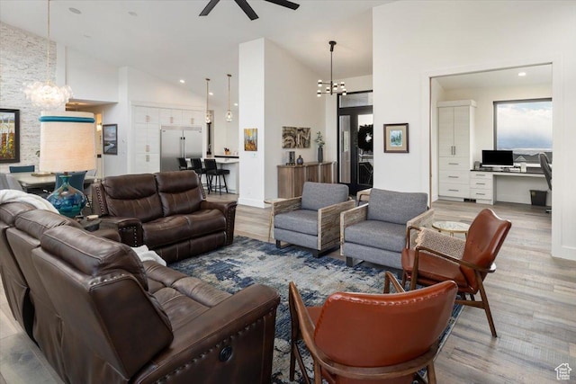 3450 N 1930 E, North Logan, UT 84341 - living room featuring ceiling fan with notable chandelier, built in desk, high vaulted ceiling, and light wood-type flooring