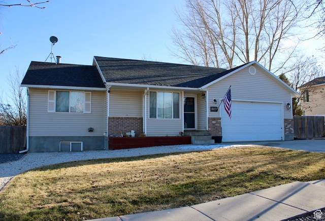 ranch-style house with brick siding, a front lawn, fence, a garage, and driveway