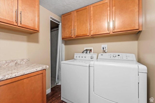washroom with washer and dryer, cabinet space, dark wood-type flooring, and a textured ceiling
