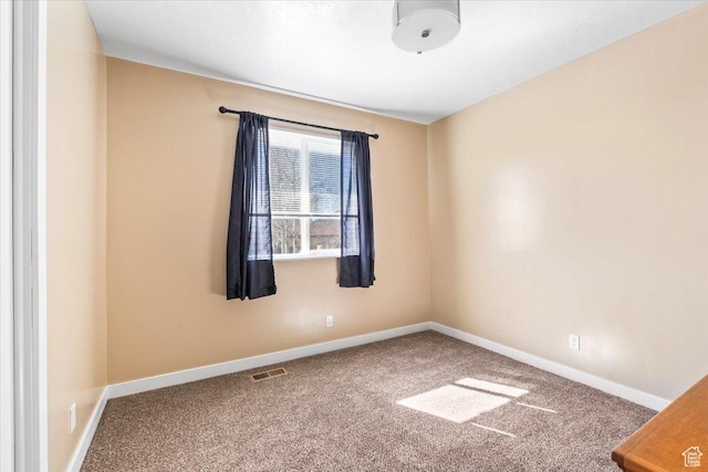 carpeted spare room featuring baseboards