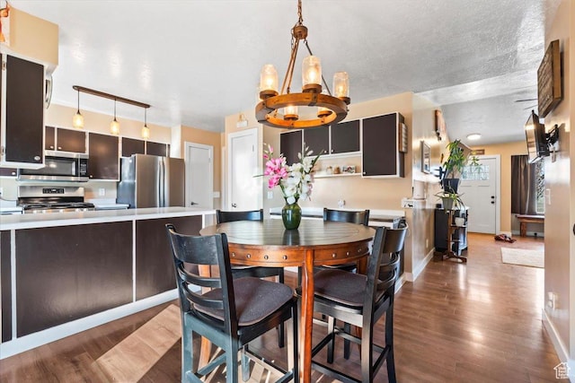 dining area featuring a chandelier, wood finished floors, and baseboards
