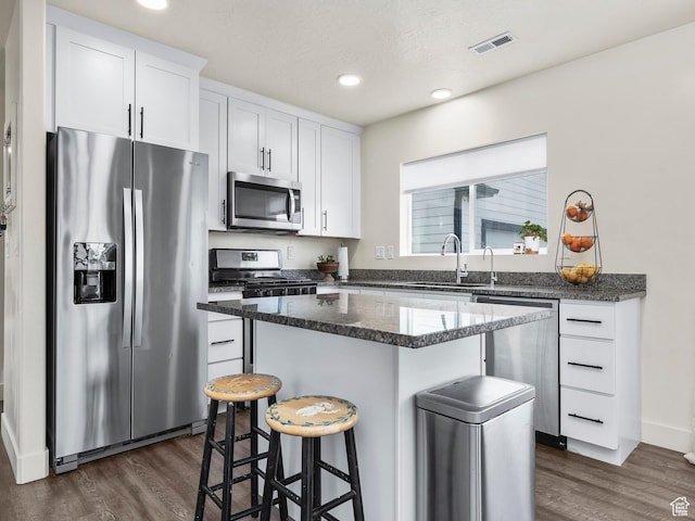 1802 E Magnolia Cir, Eagle Mountain, UT 84005 - kitchen with a kitchen island, white cabinetry, sink, dark stone counters, and stainless steel appliances