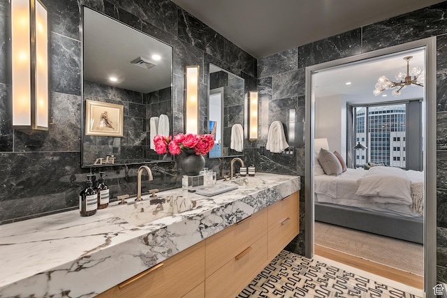 99 W S Temple St S Unit 2201, Salt Lake City, UT 84101 - bathroom featuring a notable chandelier, tile walls, vanity, and tasteful backsplash