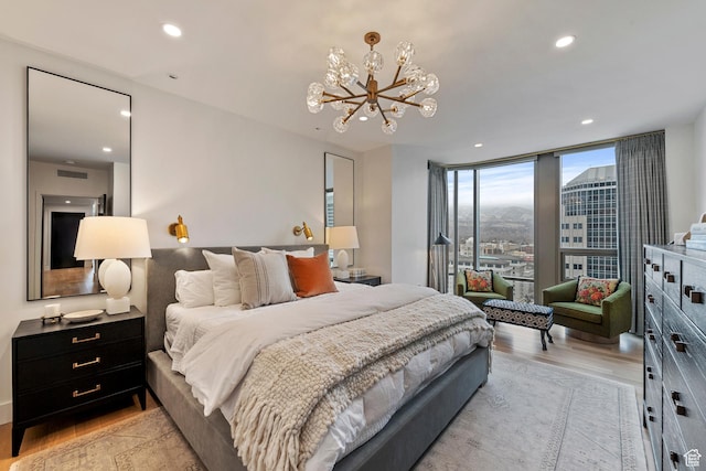 99 W S Temple St S Unit 2201, Salt Lake City, UT 84101 - bedroom with a notable chandelier, light wood-type flooring, and a wall of windows