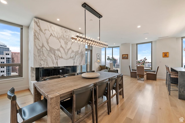 99 W S Temple St S Unit 2201, Salt Lake City, UT 84101 - dining space with light wood-type flooring, plenty of natural light, and a premium fireplace