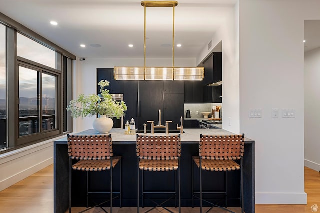 99 W S Temple St S Unit 2201, Salt Lake City, UT 84101 - kitchen featuring light wood-type flooring, sink, a breakfast bar area, and kitchen peninsula