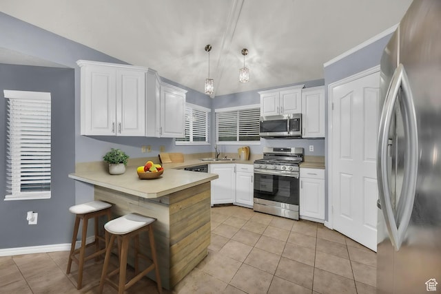 2152 E 3325 N, Layton, UT 84040 - kitchen with white cabinets, a peninsula, lofted ceiling, stainless steel appliances, and light tile patterned flooring