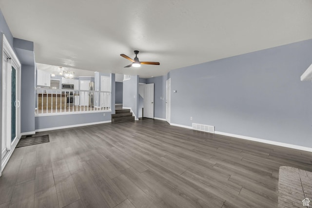 2152 E 3325 N, Layton, UT 84040 - unfurnished living room featuring visible vents, dark wood finished floors, ceiling fan with notable chandelier, and baseboards