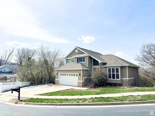 2152 E 3325 N, Layton, UT 84040 - view of front of house featuring fence, stone siding, stucco siding, a front yard, and driveway