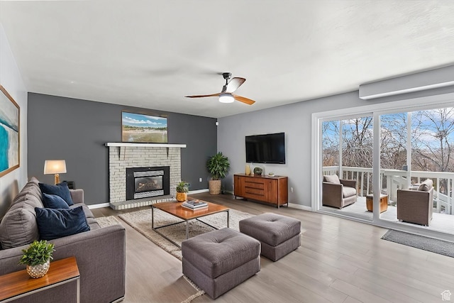 2152 E 3325 N, Layton, UT 84040 - living room with a brick fireplace, a ceiling fan, baseboards, and wood finished floors