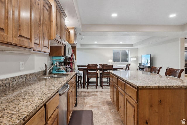 13299 S Laurel Park Ln, Draper, UT 84020 - kitchen featuring a tray ceiling, a center island, light stone countertops, a sink, and stainless steel appliances