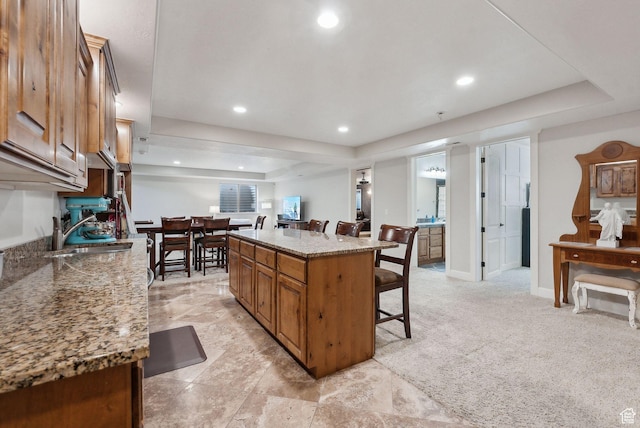 13299 S Laurel Park Ln, Draper, UT 84020 - kitchen featuring a kitchen island, a kitchen breakfast bar, recessed lighting, brown cabinets, and a sink