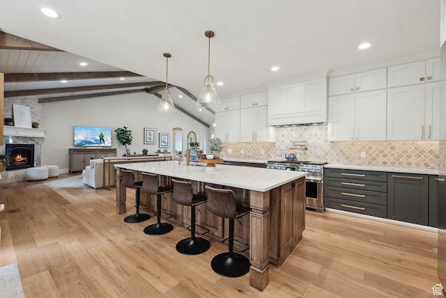 13299 S Laurel Park Ln, Draper, UT 84020 - kitchen featuring decorative backsplash, light countertops, high end stainless steel range, white cabinets, and light wood-style flooring