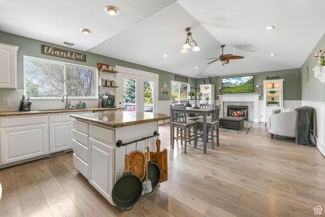 888 W Vahe St S, Draper, UT 84020 - kitchen featuring white cabinets, a warm lit fireplace, a ceiling fan, and a sink