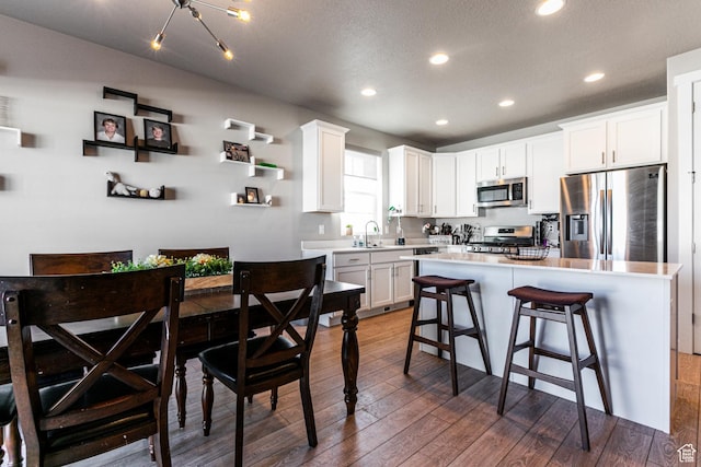 1038 W Regatta Ln, Stansbury Park, UT 84074 - kitchen with a kitchen island, white cabinets, and appliances with stainless steel finishes