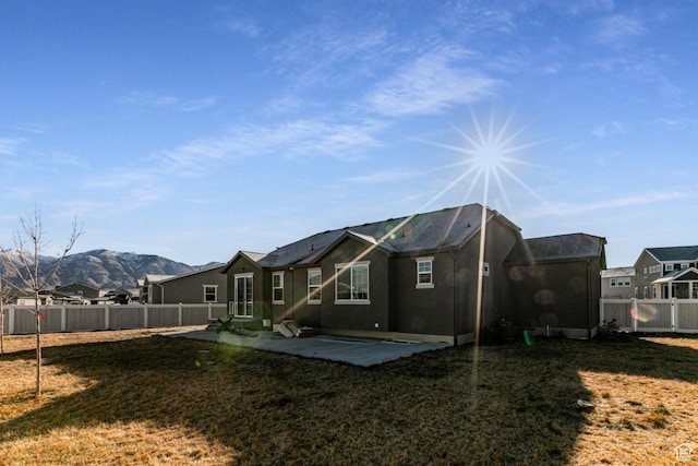 1038 W Regatta Ln, Stansbury Park, UT 84074 - back of property featuring a mountain view, a lawn, and a patio area