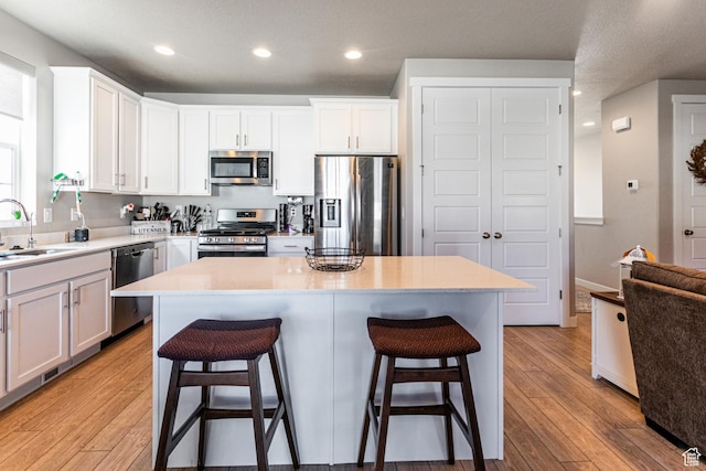 1038 W Regatta Ln, Stansbury Park, UT 84074 - kitchen with a kitchen island, appliances with stainless steel finishes, sink, and white cabinets