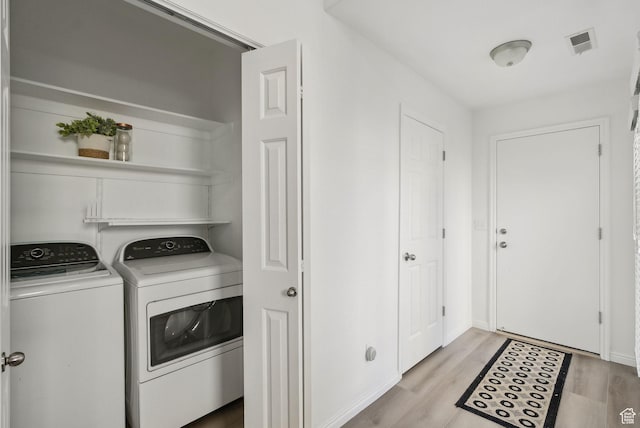 washroom with light hardwood / wood-style floors and independent washer and dryer