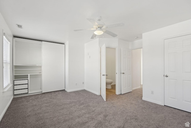 unfurnished bedroom with light colored carpet, ceiling fan, and ensuite bathroom