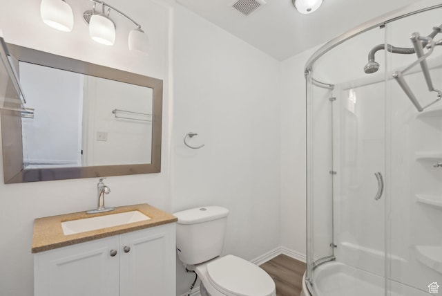 bathroom featuring an enclosed shower, vanity, hardwood / wood-style flooring, and toilet
