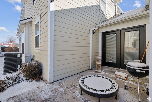 property entrance featuring a patio and central air condition unit