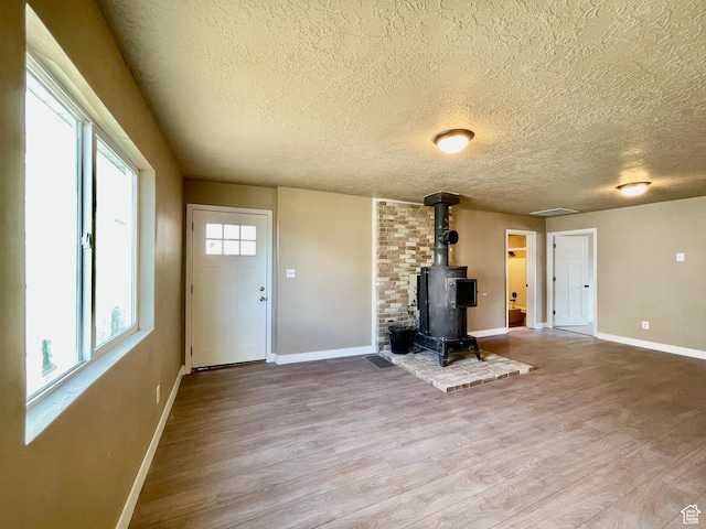 255 W Main St, Mount Pleasant, UT 84647 - unfurnished living room with wood finished floors, a wood stove, and a textured ceiling