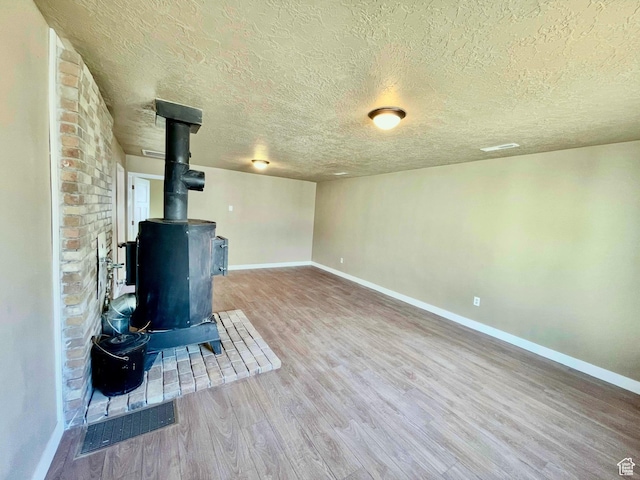 255 W Main St, Mount Pleasant, UT 84647 - unfurnished living room with a wood stove, a textured ceiling, and wood finished floors