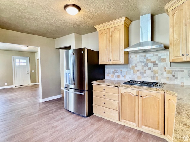 255 W Main St, Mount Pleasant, UT 84647 - kitchen with wall chimney exhaust hood, light brown cabinets, appliances with stainless steel finishes, light wood-style floors, and backsplash