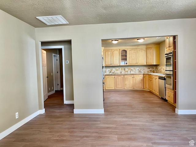 255 W Main St, Mount Pleasant, UT 84647 - kitchen featuring light brown cabinetry, stainless steel dishwasher, wood finished floors, tasteful backsplash, and a textured ceiling
