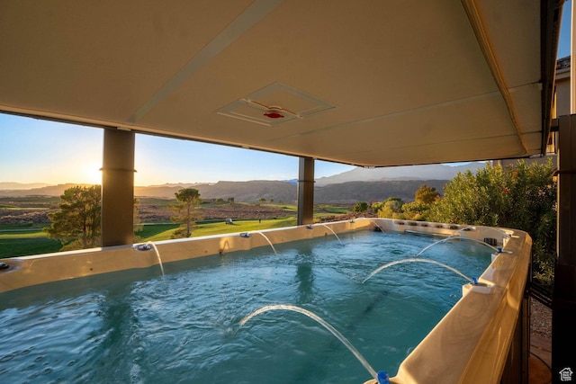 view of swimming pool featuring a hot tub and a mountain view