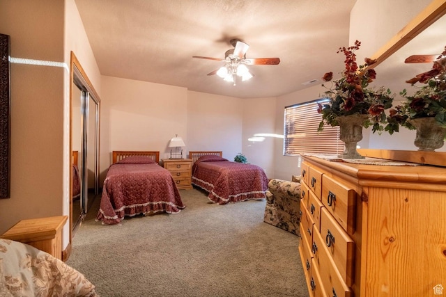 bedroom with ceiling fan, carpet, and a textured ceiling