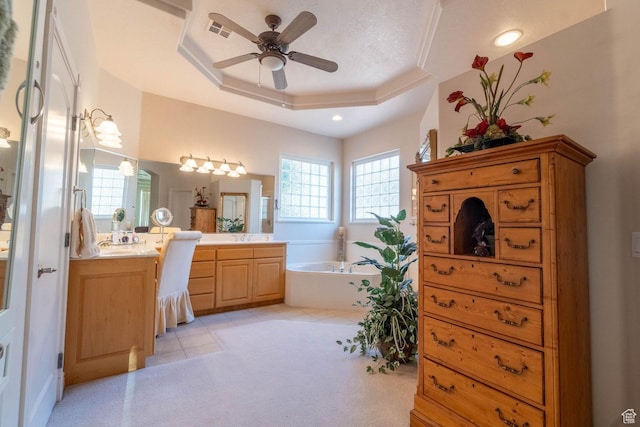 bathroom with a bathtub, vanity, ceiling fan, a raised ceiling, and tile patterned floors