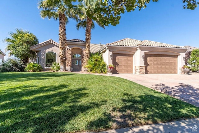 mediterranean / spanish home with a garage and a front lawn