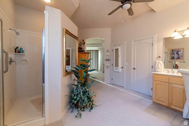 bathroom featuring ceiling fan, vanity, tile patterned flooring, and a shower with door