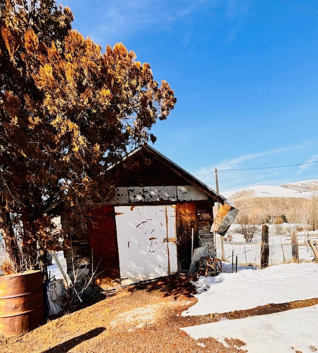 7455 N Capitol Hill Rd, Preston, ID 83263 - snow covered structure with fence, an outbuilding, and a mountain view