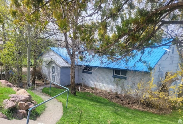 rear view of house with a yard and metal roof