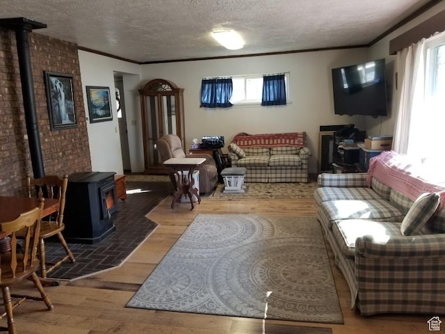 7455 N Capitol Hill Rd, Preston, ID 83263 - living area featuring a textured ceiling, a wood stove, crown molding, and hardwood / wood-style flooring