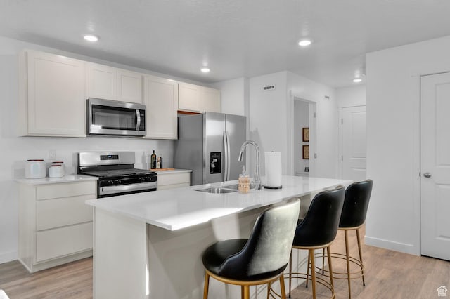 716 N 1700 E Unit 1128, Salem, UT 84653 - kitchen featuring sink, a center island with sink, light wood-type flooring, stainless steel appliances, and white cabinets