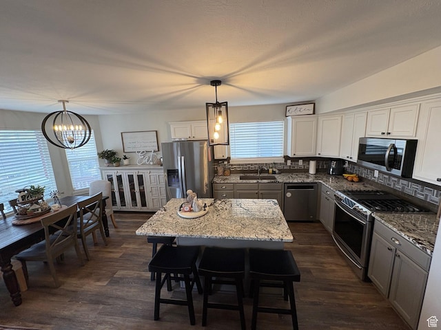 840 N Great View Dr E, Morgan, UT 84050 - kitchen with stainless steel appliances, a chandelier, a sink, light stone counters, and decorative backsplash