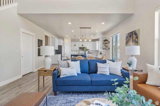 living area featuring light wood-style flooring, baseboards, and recessed lighting